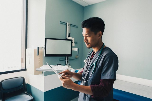 Male caregiver looking at an ipad in an office